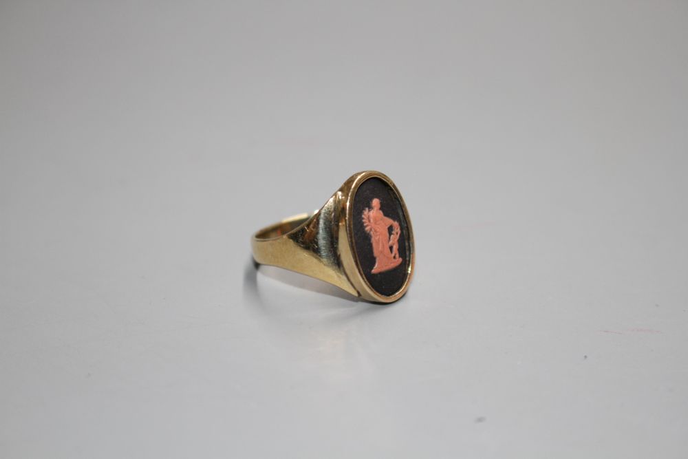 A yellow metal and oval Wedgwood plaque set ring, decorated with a lady and cherub,